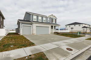 View of front of house with an attached garage, concrete driveway, and covered porch