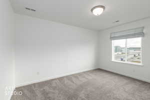 Spare room featuring light carpet and baseboards