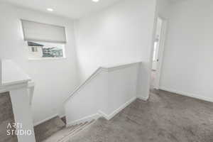 Stairway with carpet flooring and recessed lighting