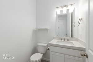 Half bathroom featuring vanity and toilet