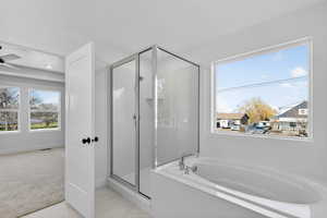 Bathroom featuring a stall shower, a garden tub, and light marble finish floors