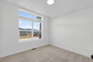 Carpeted spare room with a mountain view and a textured ceiling