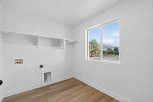 Laundry room featuring hookup for an electric dryer, light wood-style floors, hookup for a washing machine, and a mountain view