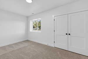 Unfurnished bedroom with carpet and a closet