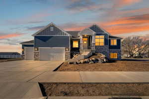 Craftsman-style home featuring stone siding, board and batten siding, and driveway