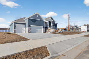 Craftsman house with concrete driveway, stone siding, board and batten siding, and an attached garage