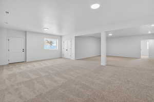 Basement featuring light carpet and baseboards