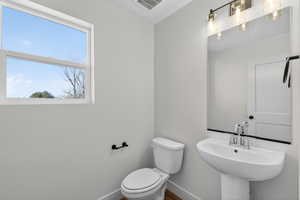 Half bathroom with toilet and baseboards