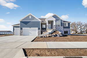 Craftsman-style house with stone siding, board and batten siding, and driveway
