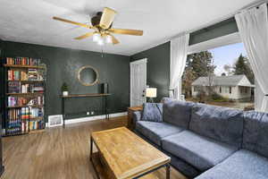 Living room featuring wood finished floors and a ceiling fan