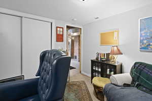 Home office featuring light carpet and a textured ceiling