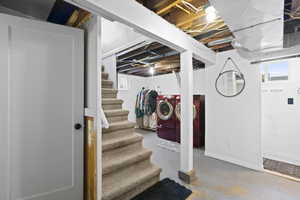 Below grade area featuring healthy amount of natural light, stairway, and washing machine and clothes dryer