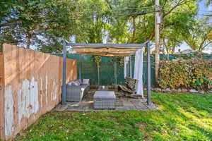 Fenced backyard featuring a patio area and an outdoor hangout area