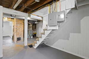 Unfinished below grade area with stairway and electric panel