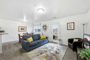 Carpeted living area featuring baseboards