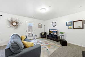 Carpeted living area featuring baseboards