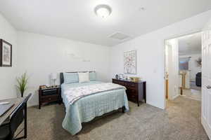 Carpeted bedroom featuring attic access and baseboards