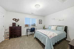 Carpeted bedroom featuring baseboards and a desk