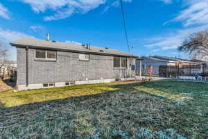 Rear view of property with brick siding and a shingled roof