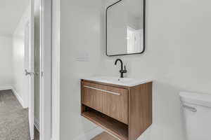 Bathroom with vanity and light colored carpet
