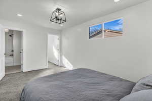 Carpeted bedroom with recessed lighting and ensuite bath