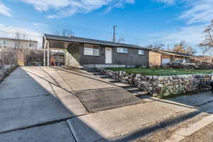 Ranch-style house with brick siding, a carport, concrete driveway, and a shingled roof
