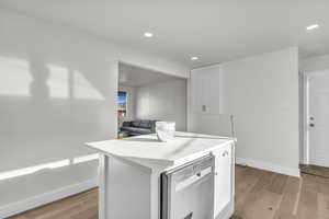 Kitchen with white cabinetry, light countertops, dishwasher, a center island, and recessed lighting
