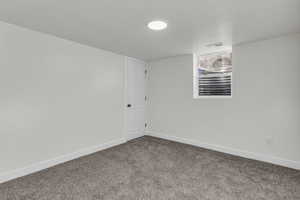 Carpeted empty room featuring baseboards