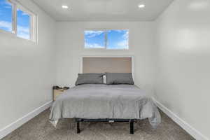 Bedroom featuring carpet floors, multiple windows, and recessed lighting