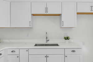 Kitchen featuring white cabinetry and light stone countertops