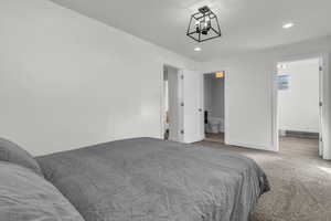 Bedroom featuring light carpet, recessed lighting, and ensuite bathroom