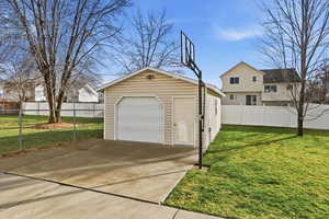 Detached garage featuring concrete driveway
