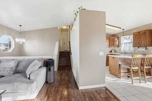 Living area with LVP flooring, stairs, and a chandelier