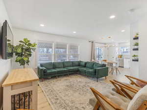 Living room featuring light wood-type flooring, recessed lighting, and a chandelier