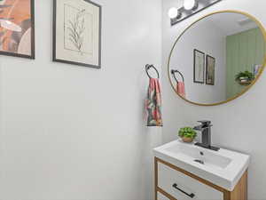 Half Bathroom featuring vanity and a textured wall