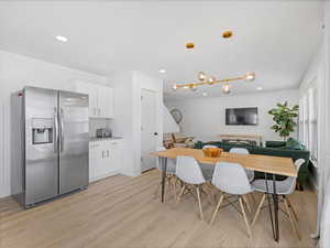 Dining space with light wood finished floors, recessed lighting, and a chandelier