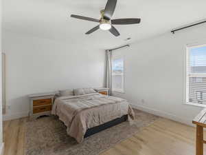 Primary Bedroom with ceiling fan and light wood-type flooring