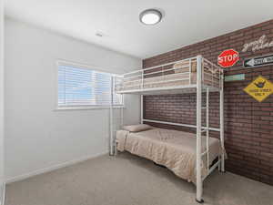 Bedroom #3 with brick wall and carpet floors