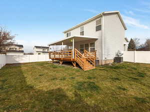 Rear view of property with a fenced backyard and a wooden deck