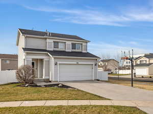 Traditional home with driveway, a garage, and a shingled roof