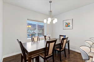 Dining space with dark wood finished floors and a chandelier