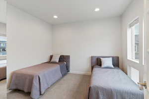 Carpeted bedroom with multiple windows and recessed lighting