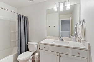 Bathroom featuring shower / bath combination with curtain and vanity