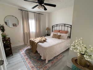 Bedroom with light wood finished floors and a ceiling fan