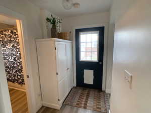 Doorway to outside featuring wood finished floors and baseboards