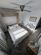 Carpeted bedroom with a desk, a ceiling fan, and a closet