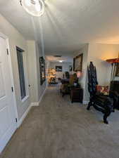 Corridor featuring carpet flooring and a textured ceiling