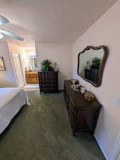 Bedroom featuring carpet, ceiling fan, a textured ceiling, and ensuite bathroom