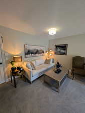 Carpeted living area featuring baseboards and a textured ceiling