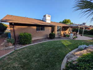 Back of house featuring a patio, brick siding, a shingled roof, and a chimney
